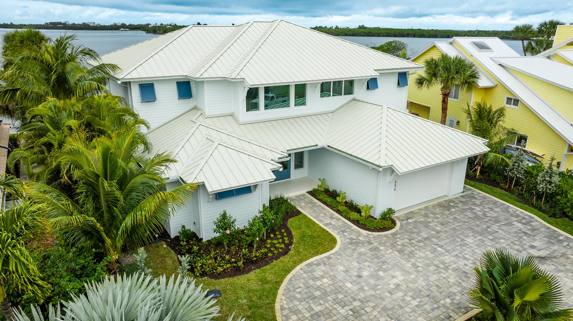 Waterfront estate with white standing seam metal roof